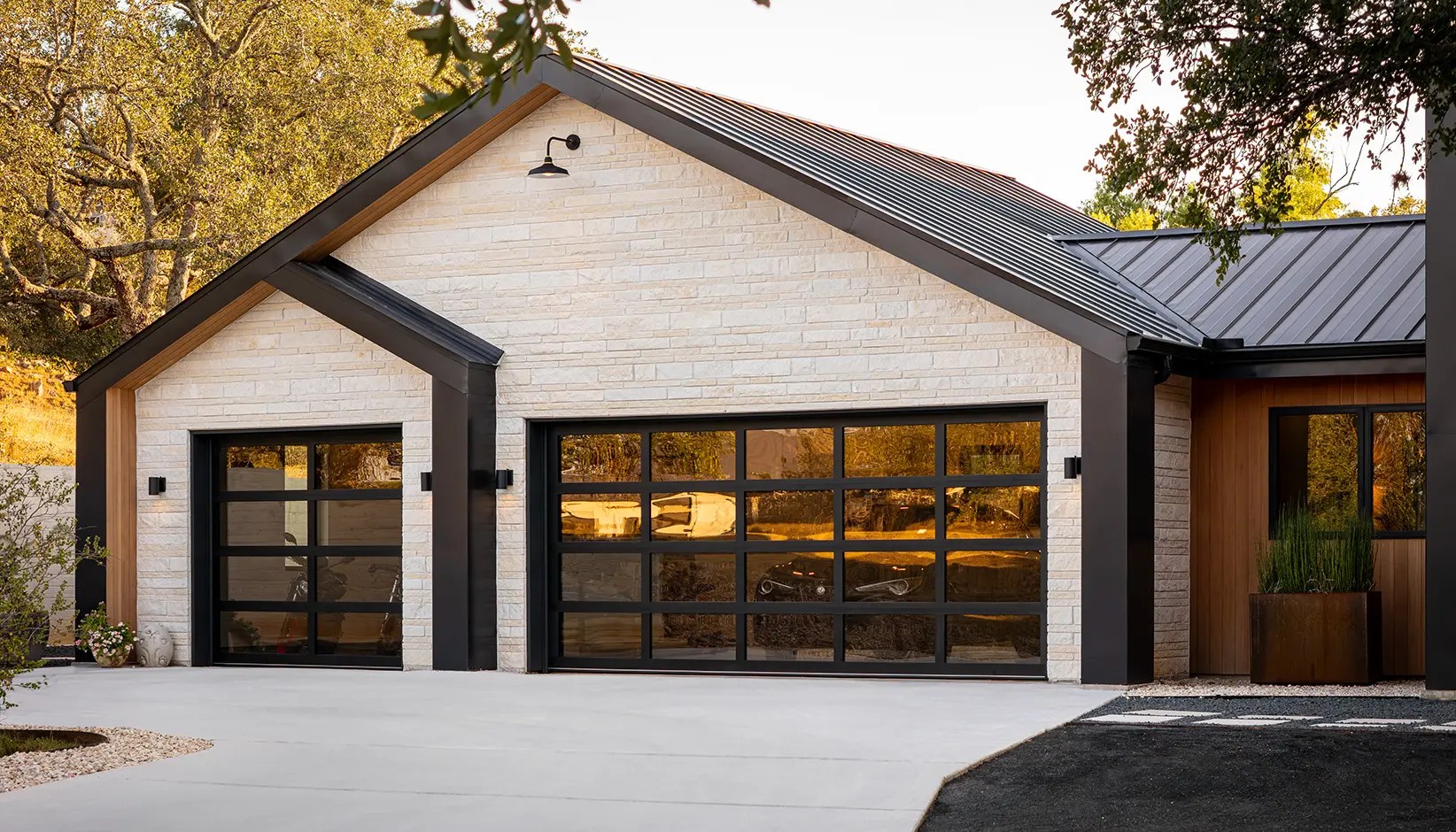 High-end glass garage door on a light stone home — Clopay manufacturer inspiration
